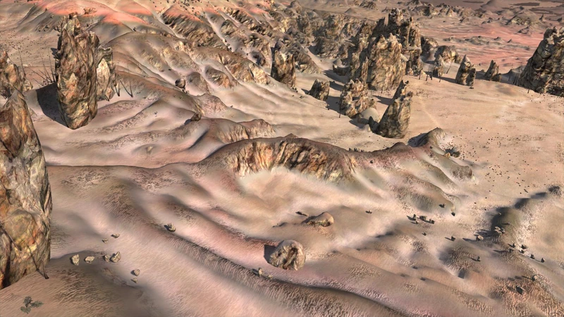 Pink-orange dunes with clusters of sharp rock spires and a low eroded ridge across the middle
